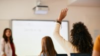 High school student raises hand in classroom