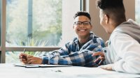 Two high school boys talking in class