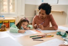 Preschool teacher and student work on a drawing together