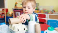 Preschooler plays with household items in class
