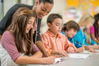 A teacher helping her middle school student with her writing