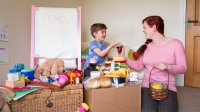 Boy pretends to have a store at home and his mother is the customer