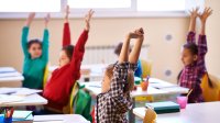 Elementary students stretching at their desks