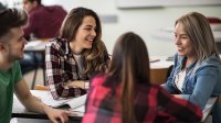 Small group of high school students happily working together in class