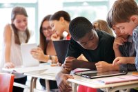 A classroom full of middle school students using tablets