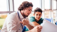 A teacher giving a student feedback about his writing