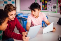 A group of high school students discussing work in the classroom