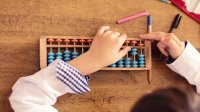 Elementary aged girl using abacus for math