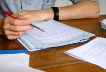 Teacher grading papers with red pen