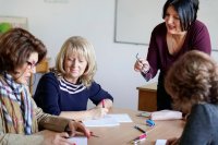 Four teachers discussing a professional development handout at a table in a classroom