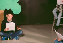 Middle school student reading script in theater class