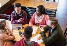 Group of high school students study together in a coffee shop