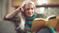 Woman reading a book on her couch