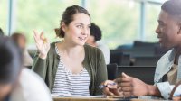 Two high school students talk in class