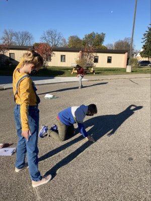 Elementary students conduct a shadow experiment outside