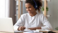 Middle school aged girl with headphones and laptop remote learning