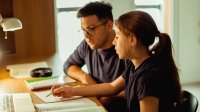 Father and daughter working on homework together at home