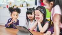 Preschool students play together on tablet