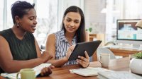 Two women in work meeting with ipad