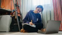 Teenager works on homework in room at home