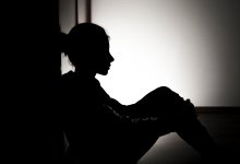 Silhouette of young teen girl sitting on floor
