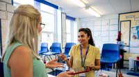 Two teachers speaking in classroom