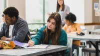 High school students writing in classroom