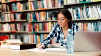 High school student studies in library