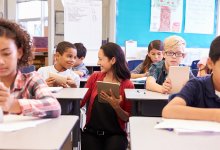 Teacher speaking with student in elementary school classroom