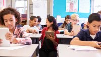 Teacher speaking with student in elementary school classroom