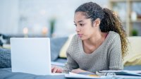 Teenage girl at home on computer remote learning