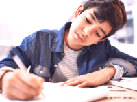 A photo of a middle school boy doing a writing assignment.