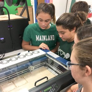 Students use a laser engraver.