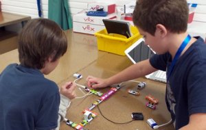 Two boys using LittleBits with batteries that light up pieces