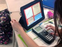 photo of a student using a calculator and tablet computer