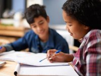 Two students looking over papers and talking