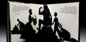 An opened pop-up book showing black silhouettes of four people working