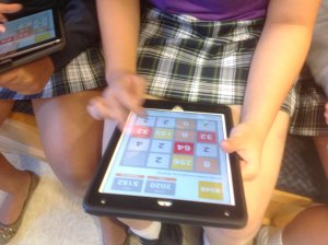 A girl plays a math game on her iPad.