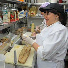 A photo of kitchen staff preparing large sandwiches.