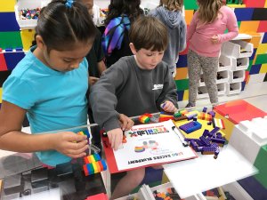 Students in a makerspace with Legos everywhere