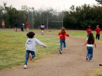 Kids running around the circle of a baseball field