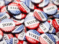 A large pile of red, white, and blue starred pins that say VOTE 2016
