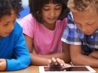 Three children around a tablet device