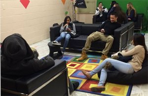 A photo of a group of high school students hanging out in the library's lounge area.