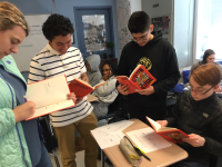 A group of teens in a classroom reading a poetry book titled Citizen Illegal by Jose Olivarez