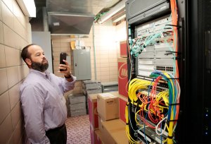 Tour guest photographs server room with his cell phone.
