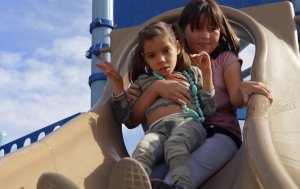 A fourth-grade student from McKinley Elementary School in Santa Monica slides down a slide with her buddy, a fellow student with special needs, during a field trip to a local playground.