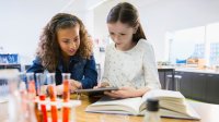 Two girls work together on a science project.