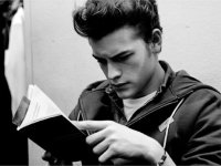 black and white photo of a young man reading a book