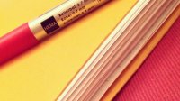 A roller 0.7 mm pen is on top of a yellow folder filled with paper.
